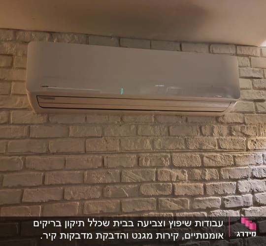 קיר לבנים צבוע בלבן עם מזגן מותקן